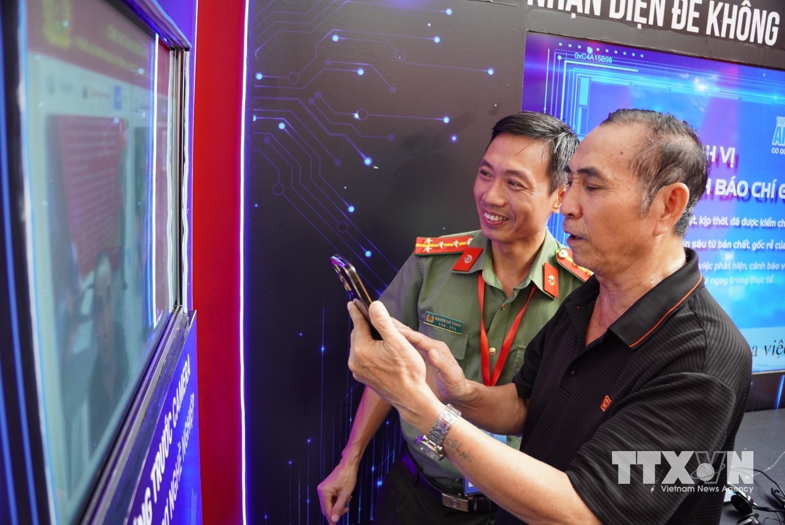 Người dân tham quan triển lãm “Bức tường An ninh mạng”được trực tiếp nhận diện những thủ đoạn lừa đảo trực tuyến phổ biến trên không gian mạng. (Ảnh: Hùng Mạnh/TTXVN)
